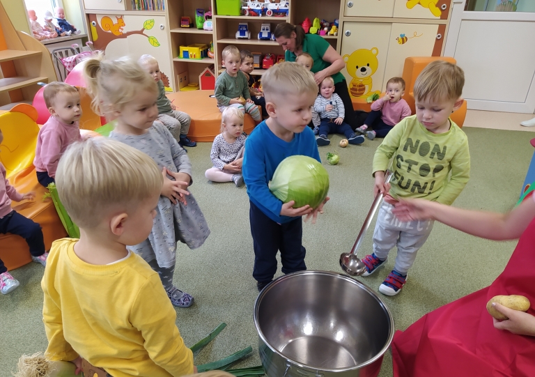 Dzieci dodaja warzywa do garnka